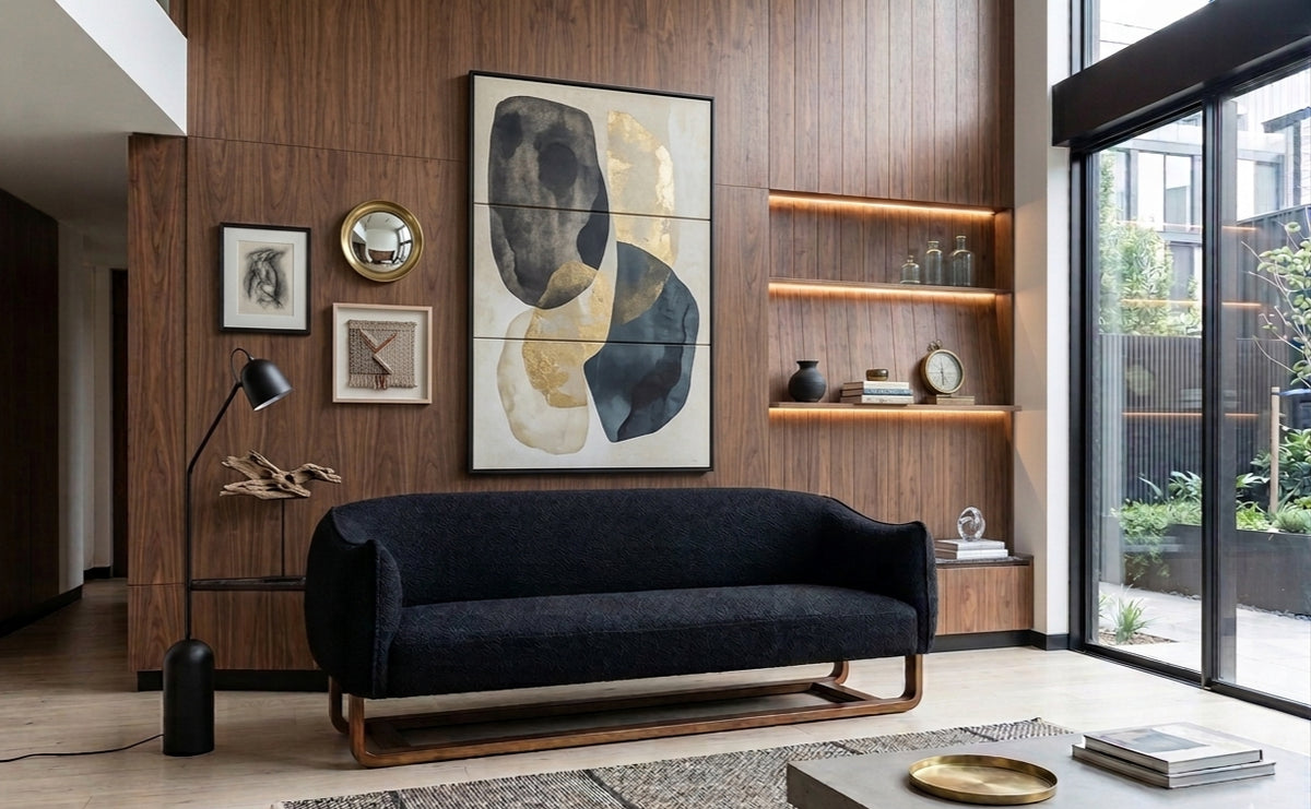 Living room with a navy sofa against walnut panelling and framed art
