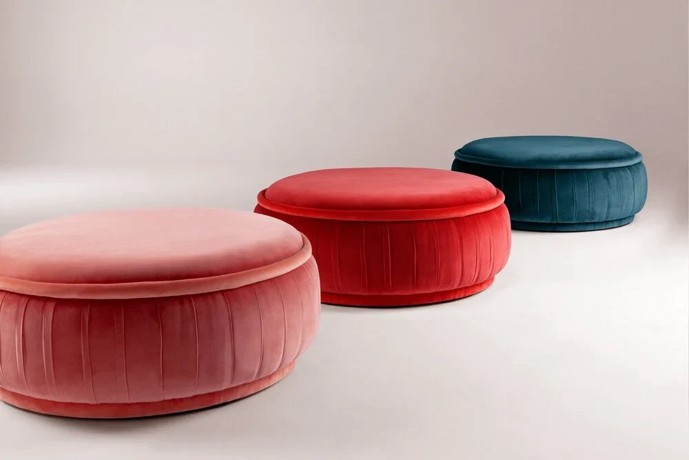 Three round velvet ottomans in pink, red and teal
