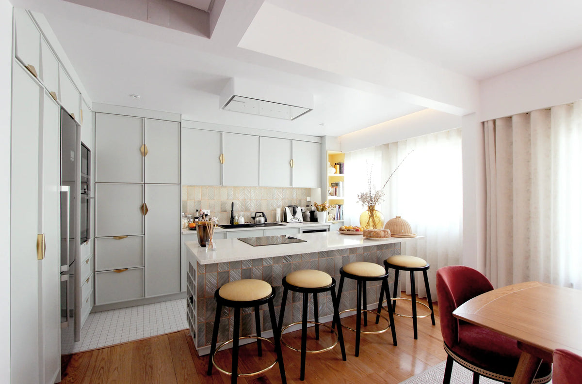 Upholstered counter stools at a kitchen island by Maison Burgos