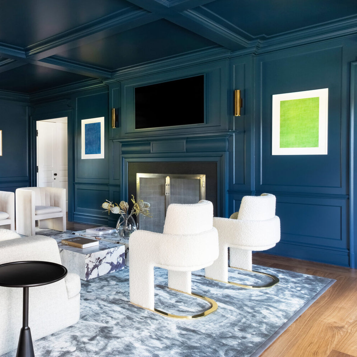 Odisseia Dining Chairs in white bouclé beside a fireplace in a navy-panelled living room