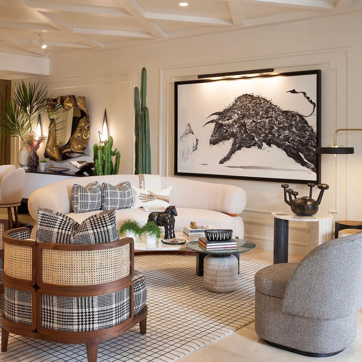 Malibu Curved Sofa in a bright living room with large bull artwork and rattan chairs