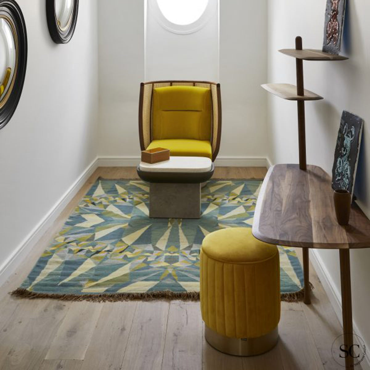 Egoista Armchair in yellow velvet in a hallway with a patterned rug and yellow ottoman