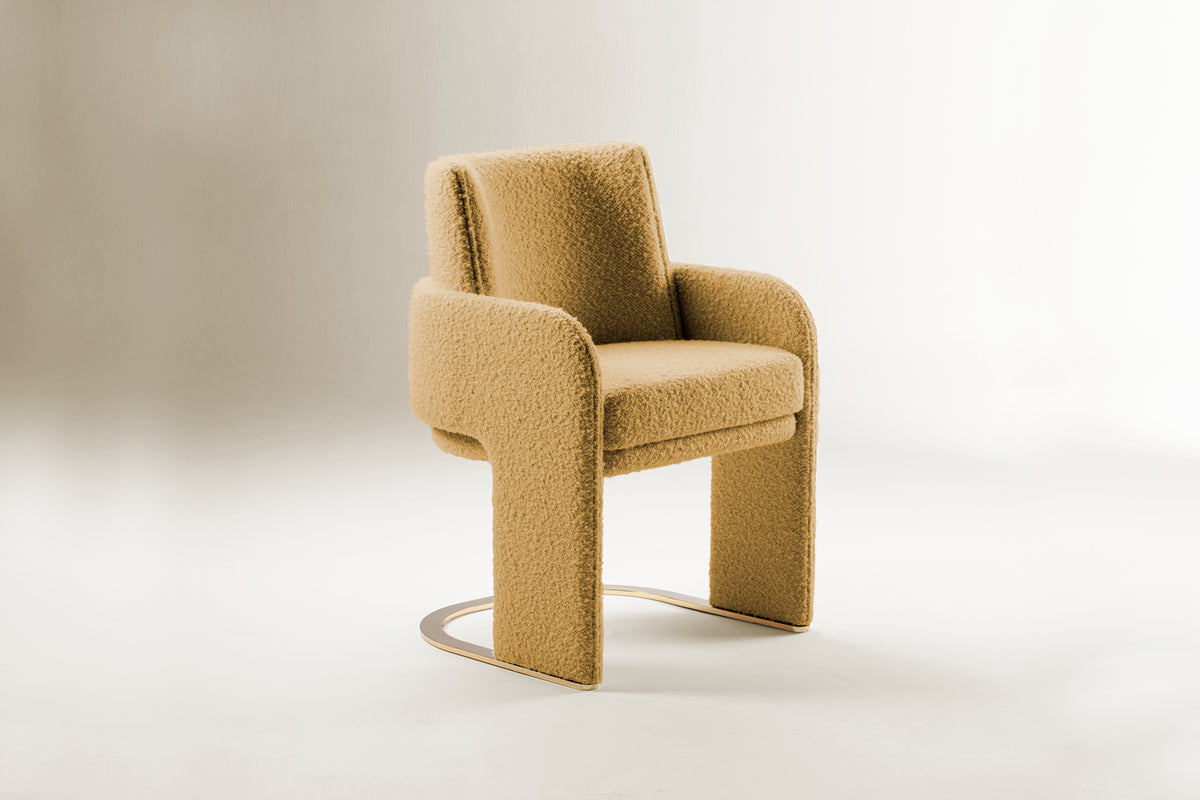 Odisseia Dining Chair in mustard bouclé, three-quarter view with brass base