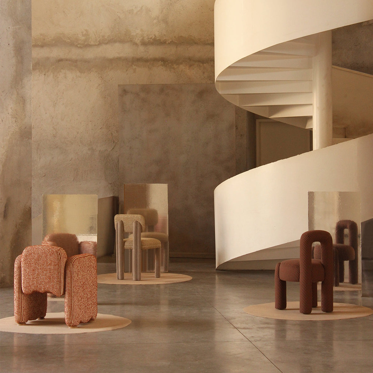 Camelia Dining Chair in a concrete atrium beside a spiral staircase with lounge chairs