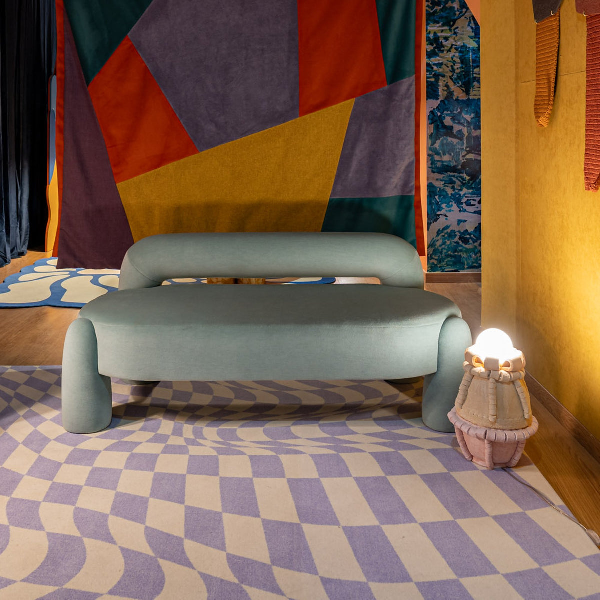 Marlon Daybed - 02 in sage before a patchwork wall hanging and checkered rug