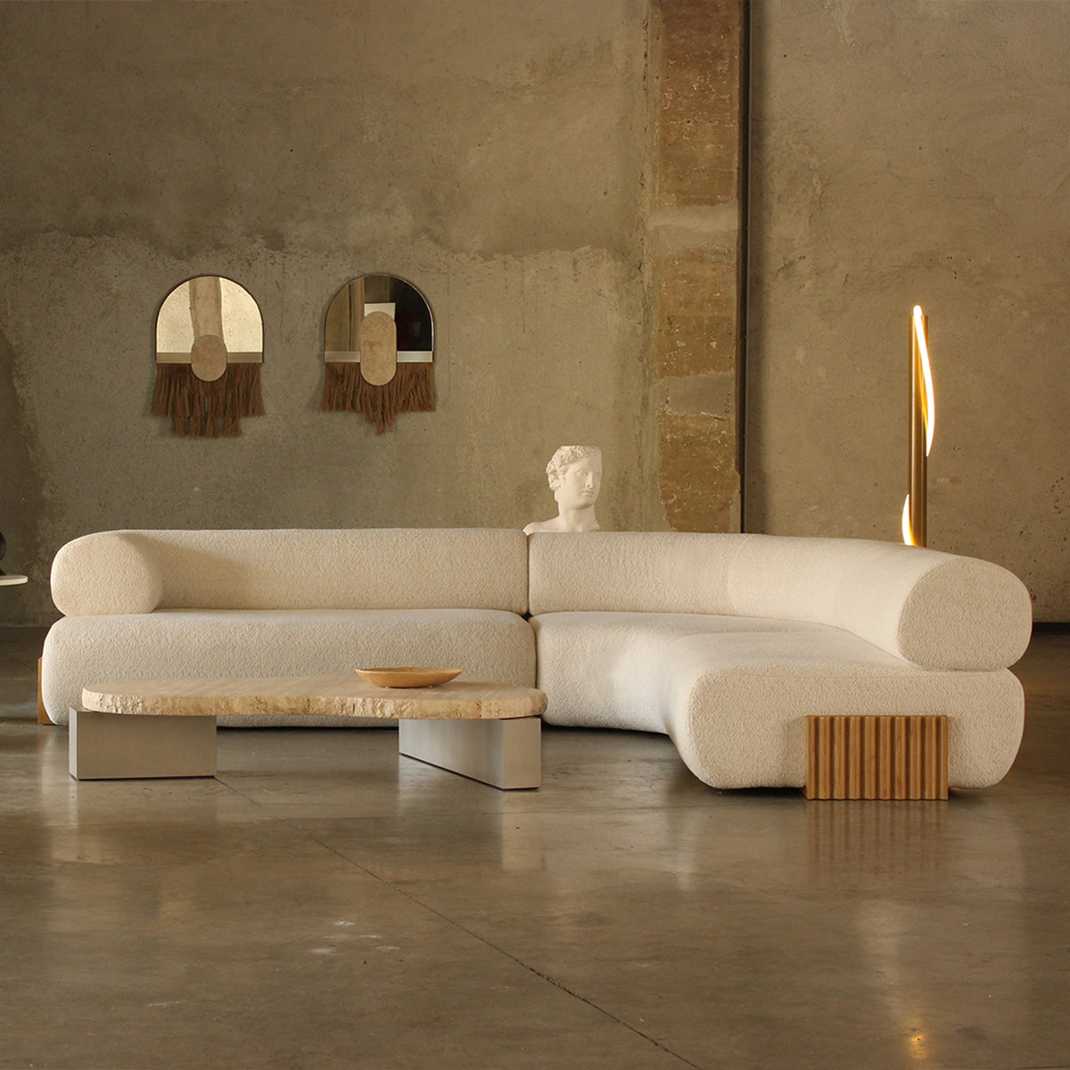 Carmel Lacquer Modular Sofa in cream boucle with fluted base in a concrete room