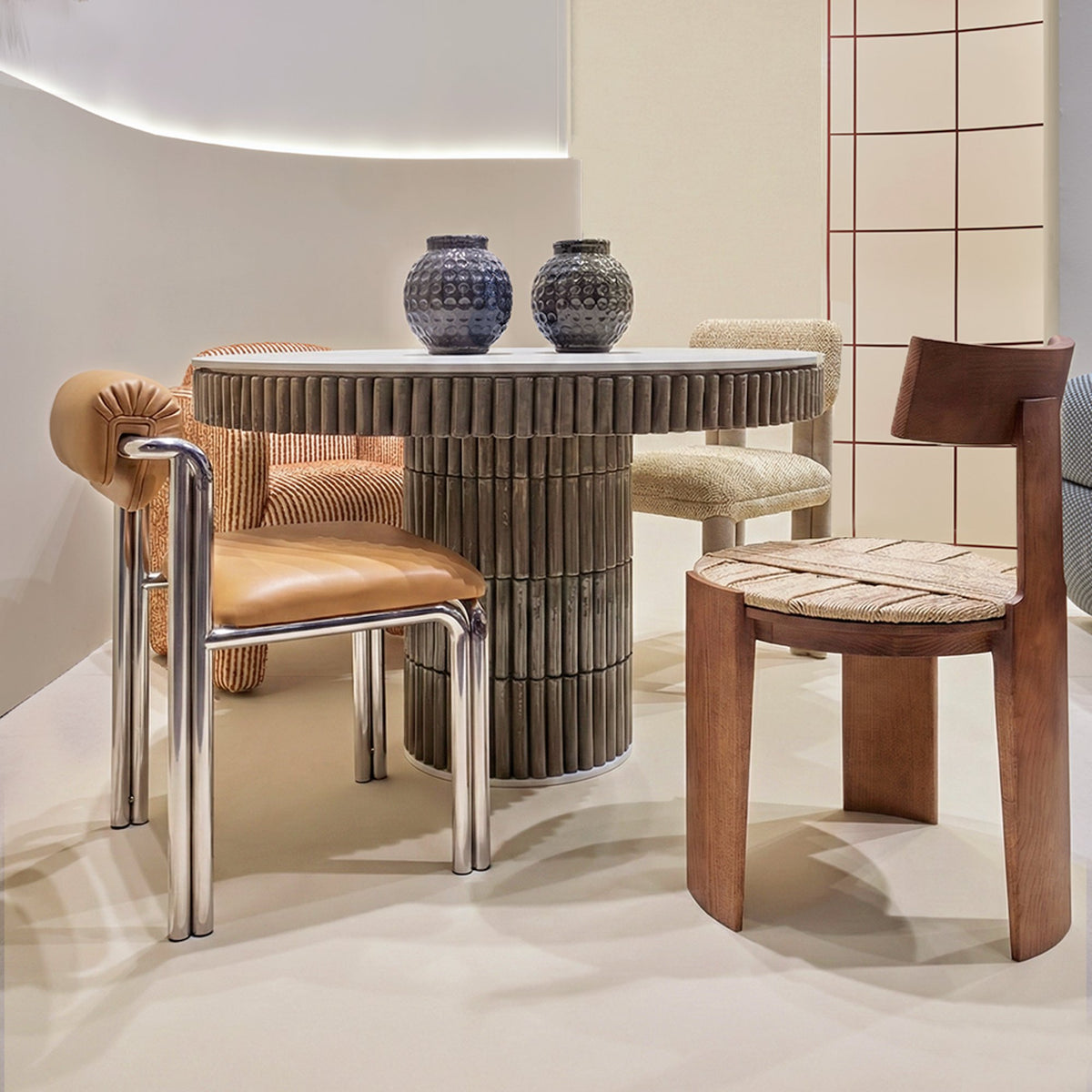 Nest Dining Chair at a round fluted table with a chrome-frame chair in a curved white room