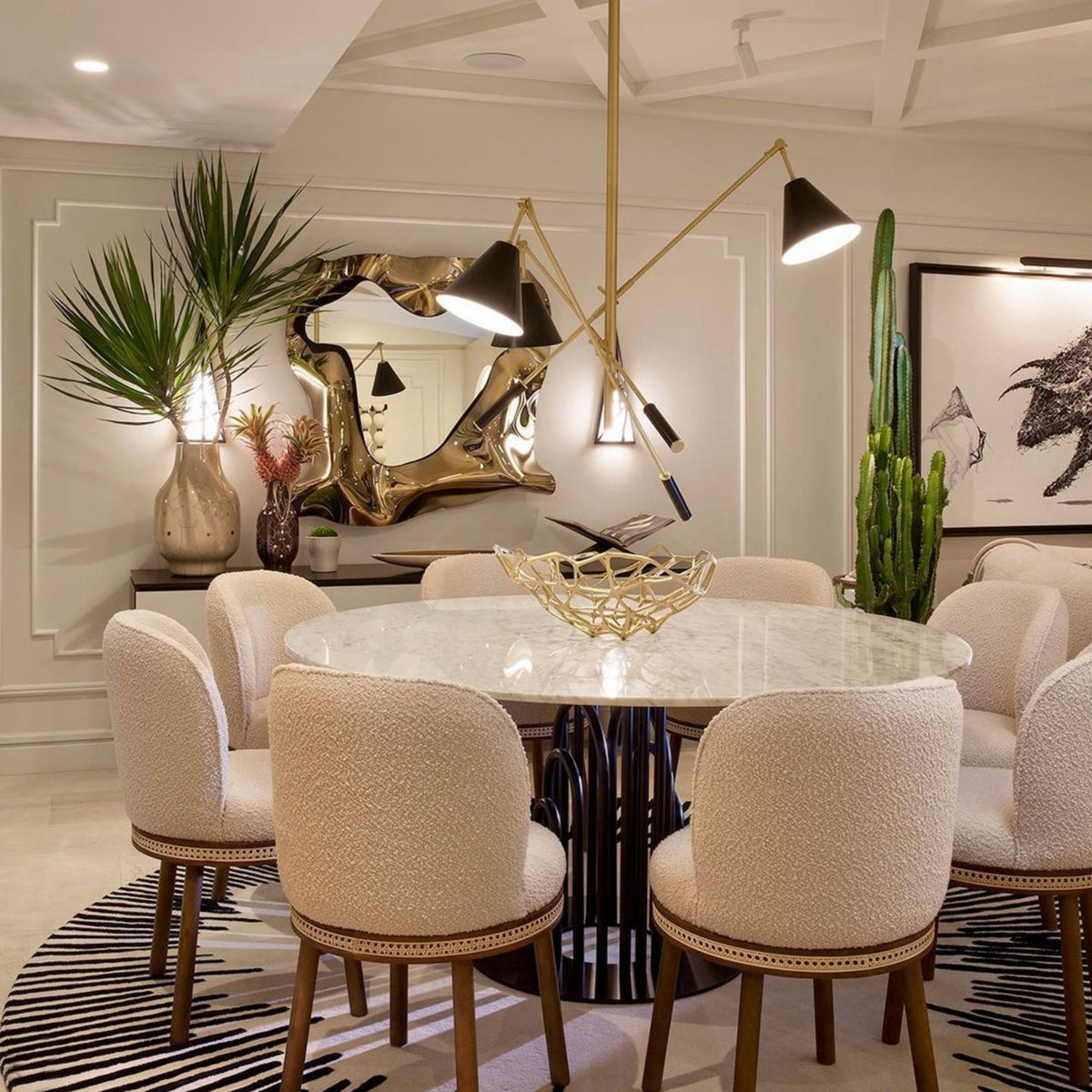 Alma Dining Chair set in blush around a marble table under a brass chandelier