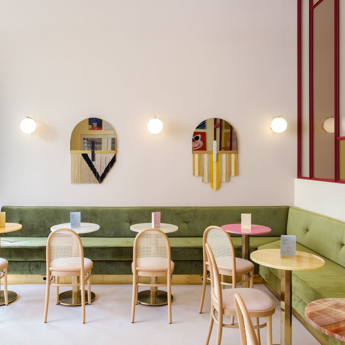 Souk Mirror Yellow on a pink café wall above a green banquette, wide view