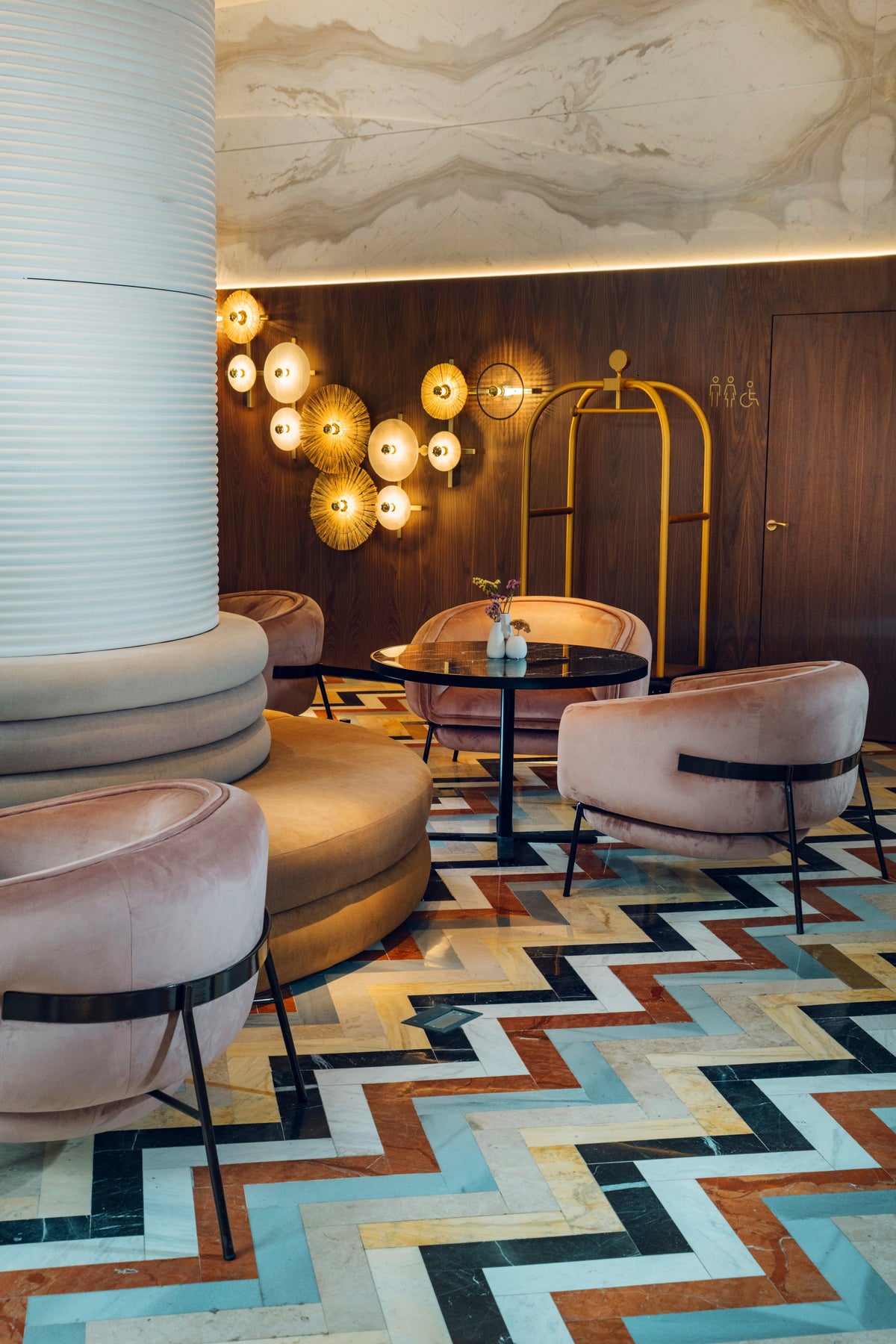 Blop Armchair in blush upholstery in a lounge with a zigzag tiled floor