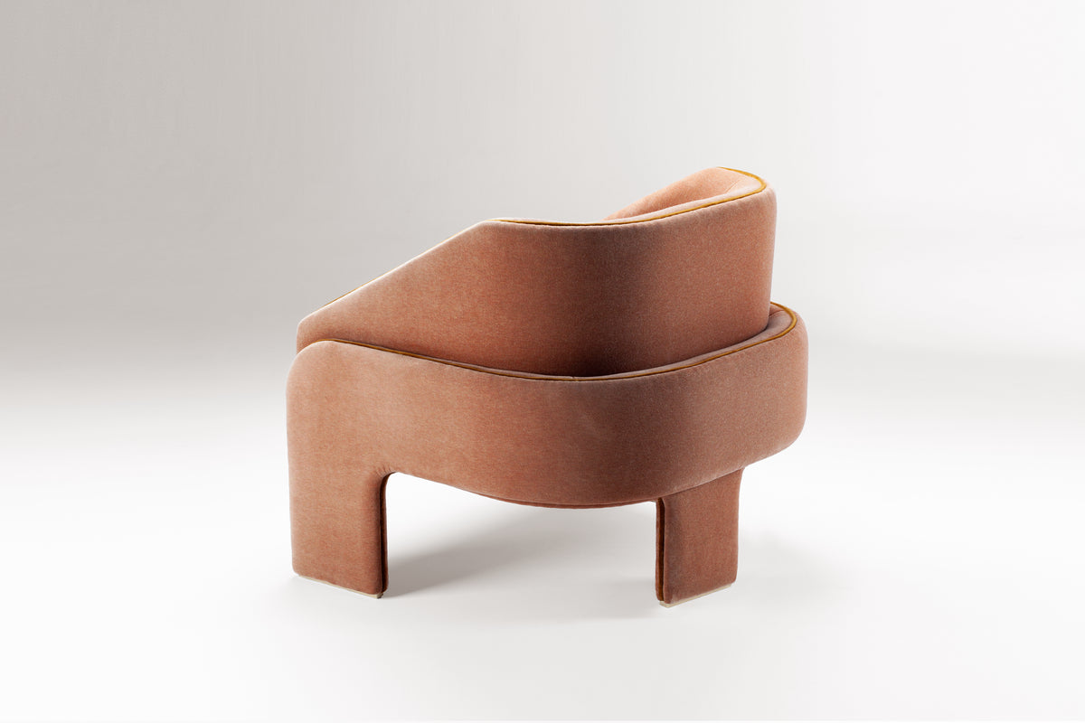 L’Unité Chair in rose velvet on a grey backdrop, side three-quarter view