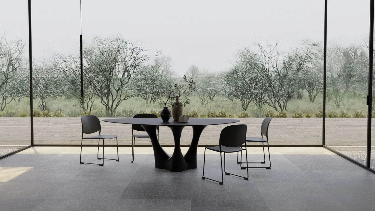 Groot Dining Table with black chairs in a glass pavilion