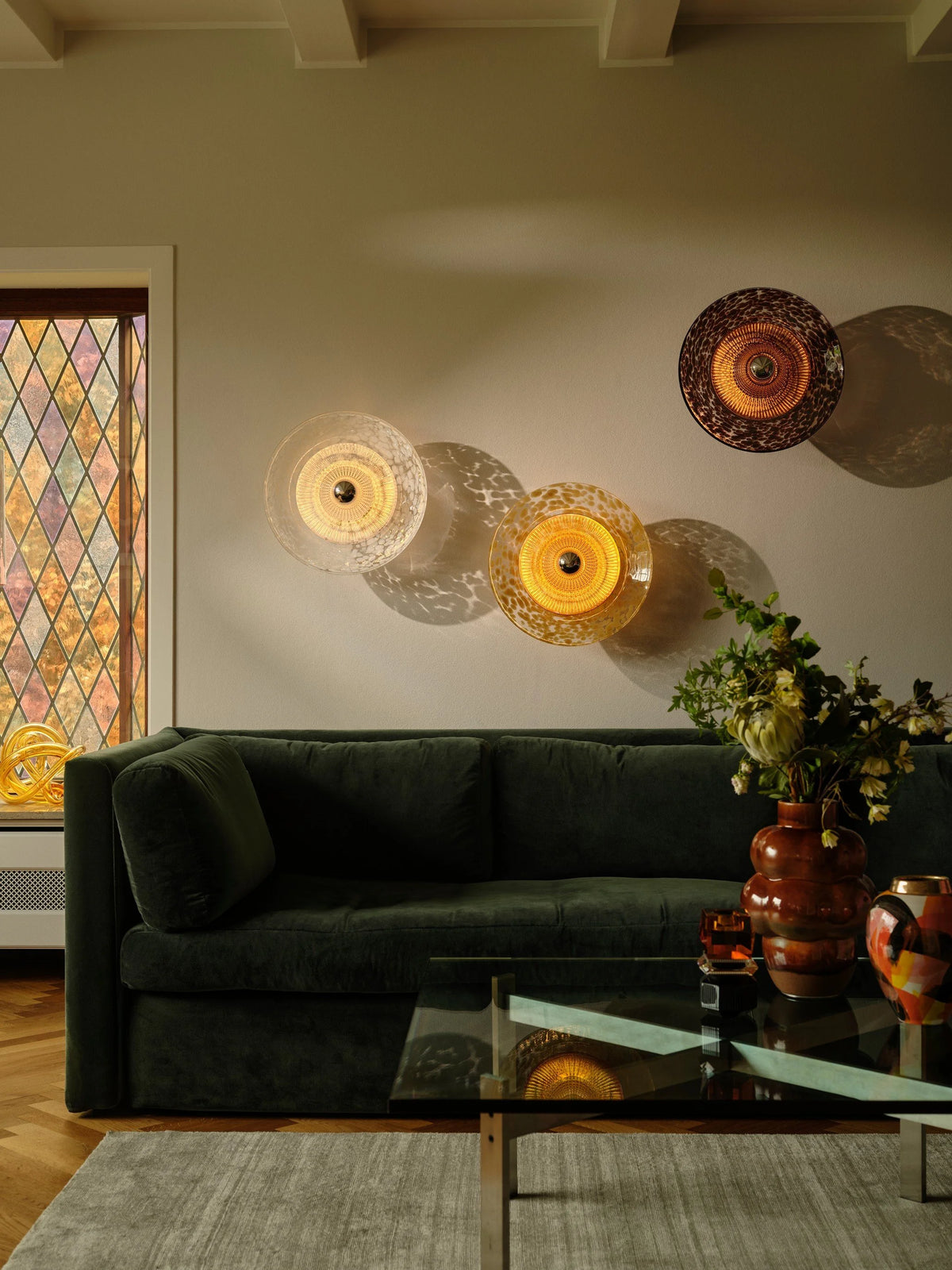 Disco Rama Wall Light Sconces glowing over a living room with a glass coffee table
