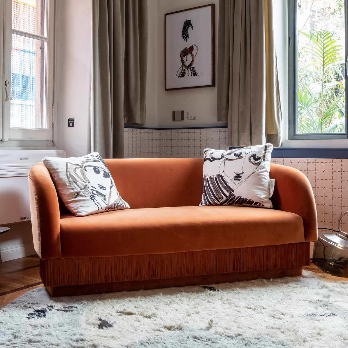 La Folie Sofa in orange velvet with printed cushions in a bright apartment
