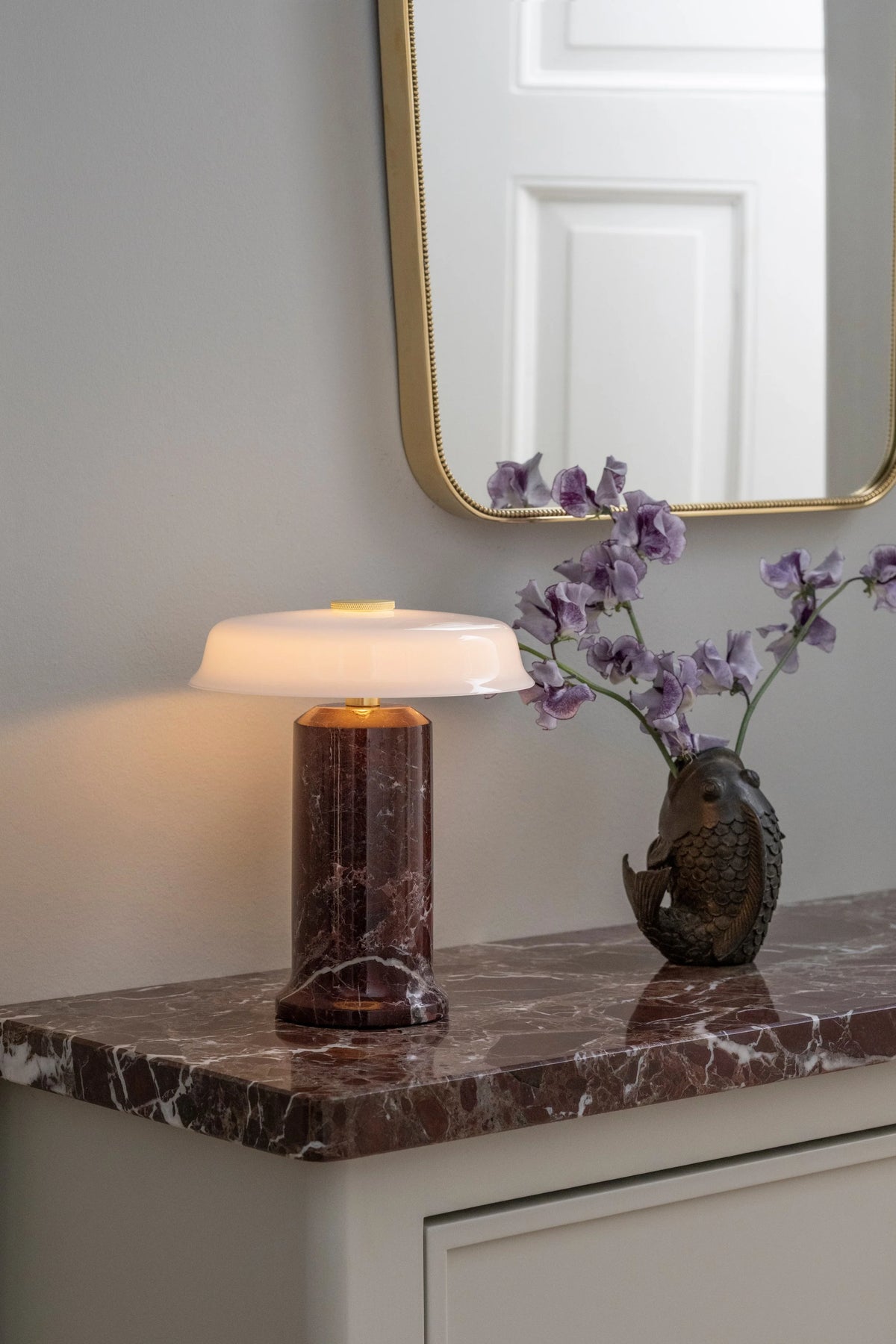 Trip 2 Table Lamp – Burgundy | Opal on a marble console with mirror and orchids