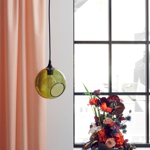 Ballroom Army Pendant Light, green glass globe lit beside a window