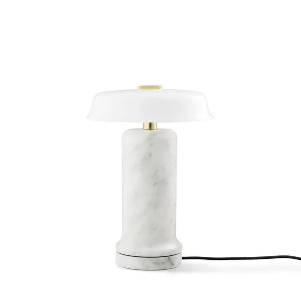 Trip 2 Table Lamp in Carrara and Opal on its charging base with cable
