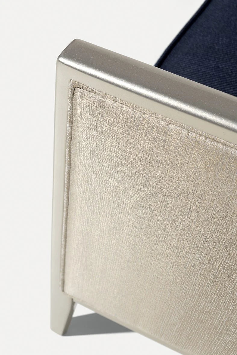 Saten Armchair, close-up of the beige woven side panel and metallic frame