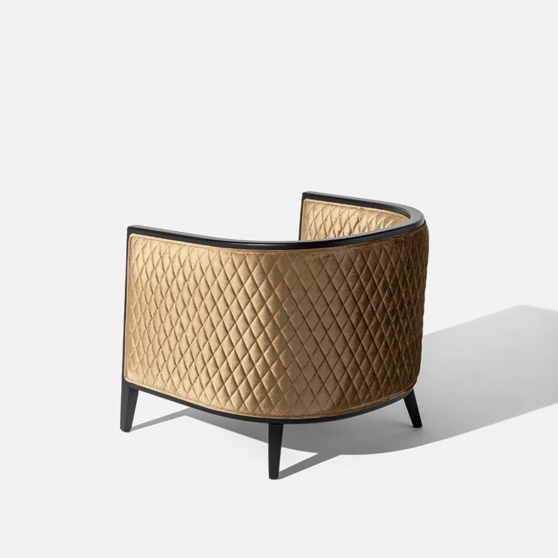 Saten Armchair in quilted tan leather with black legs, rear three-quarter view