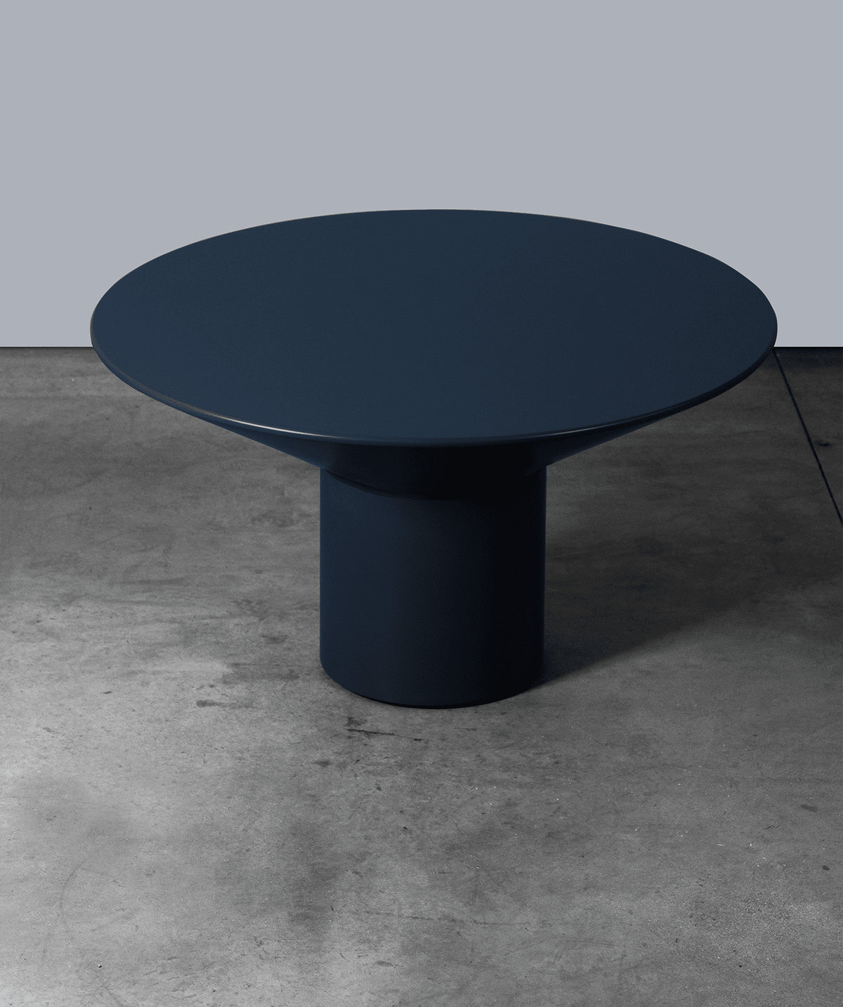 Silo Dining Table in navy blue lacquer on a concrete floor