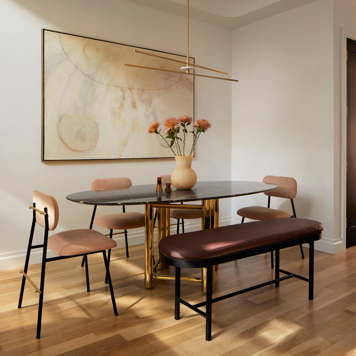 Miami Dining Chairs with a dark bench at an oval dining table in a sunlit dining room