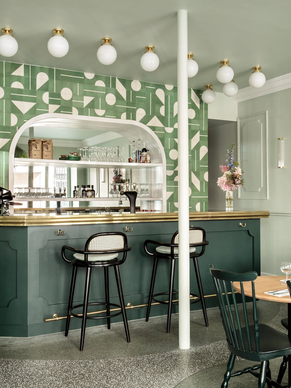 Luc bar chairs at a green tiled bistro bar
