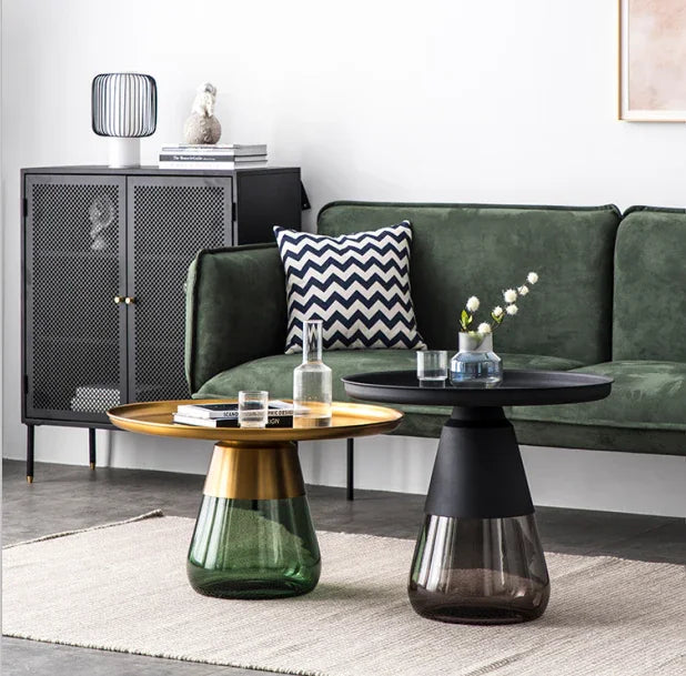 Duverre Coffee Tables in brass-green and black-smoke beside a green sofa and black cabinet