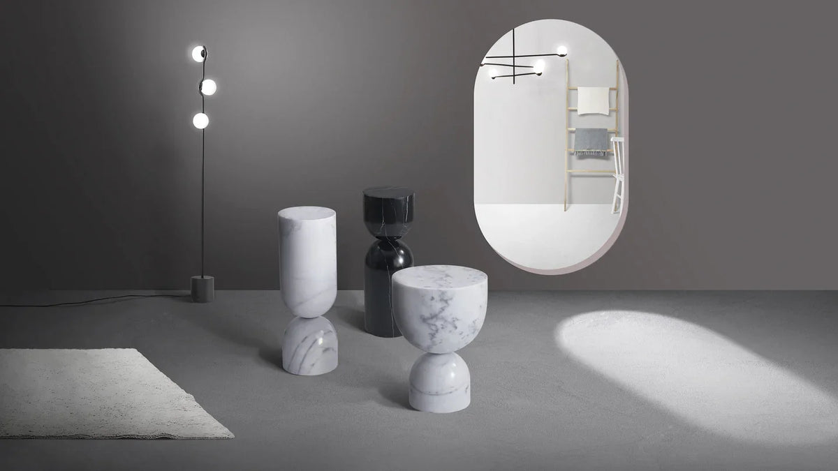 Apothecary End Table trio in white and black marble beside a floor lamp and mirror