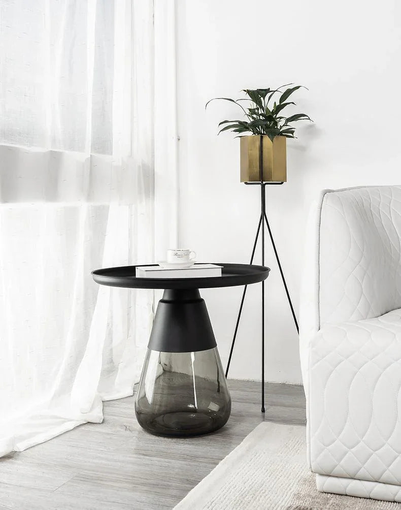 Duverre Side Table in Black Aluminum Smoke Glass beside a white armchair