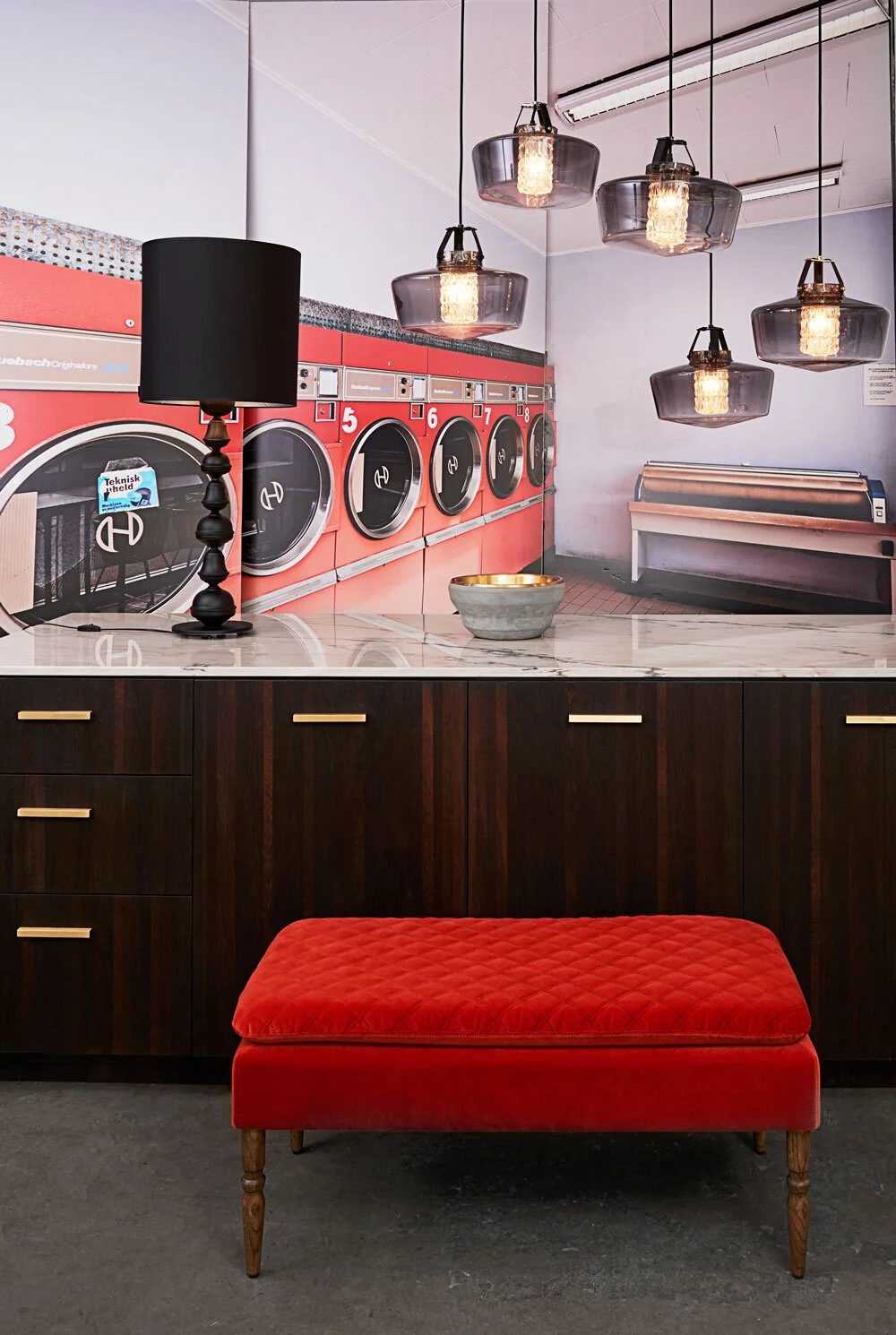 Addicted To Us Pendant Light Black cluster of smoked glass pendants over a marble counter with a red bench