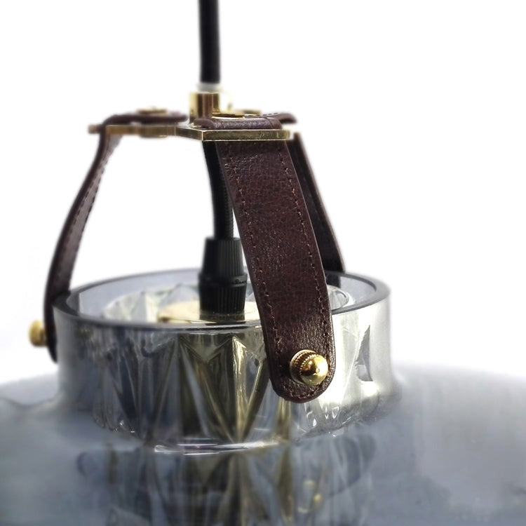Addicted To Us pendant light in brass, leather strap detail, by Maison Burgos