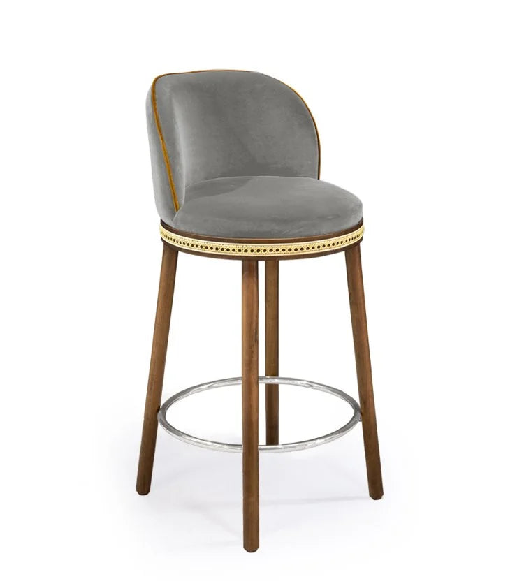 Alma Counter Stool in Fog velvet with natural walnut legs and polished nickel footrest