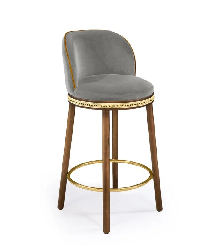 Alma Counter Stool in Fog velvet with natural walnut legs and satin brass footrest