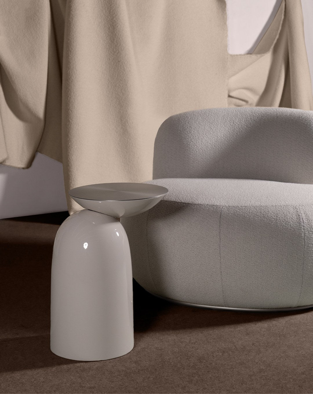 B-15 Z Lounge Chair close-up in grey bouclé beside a glossy pedestal side table