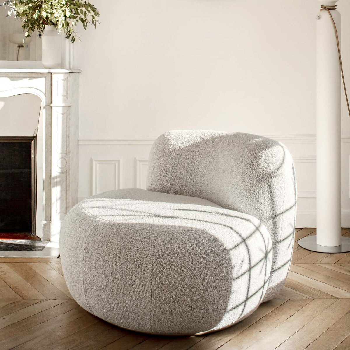 B-15 Z Lounge Chair in ivory bouclé in sunlight beside a marble fireplace