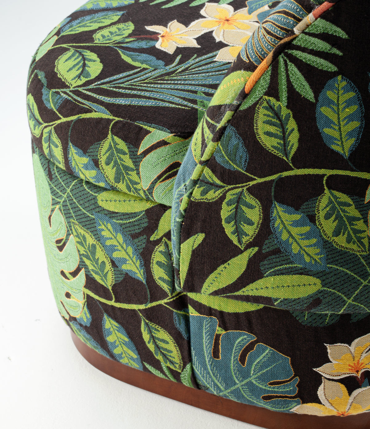 Bisou Armchair close-up of tropical leaf print fabric and wood base