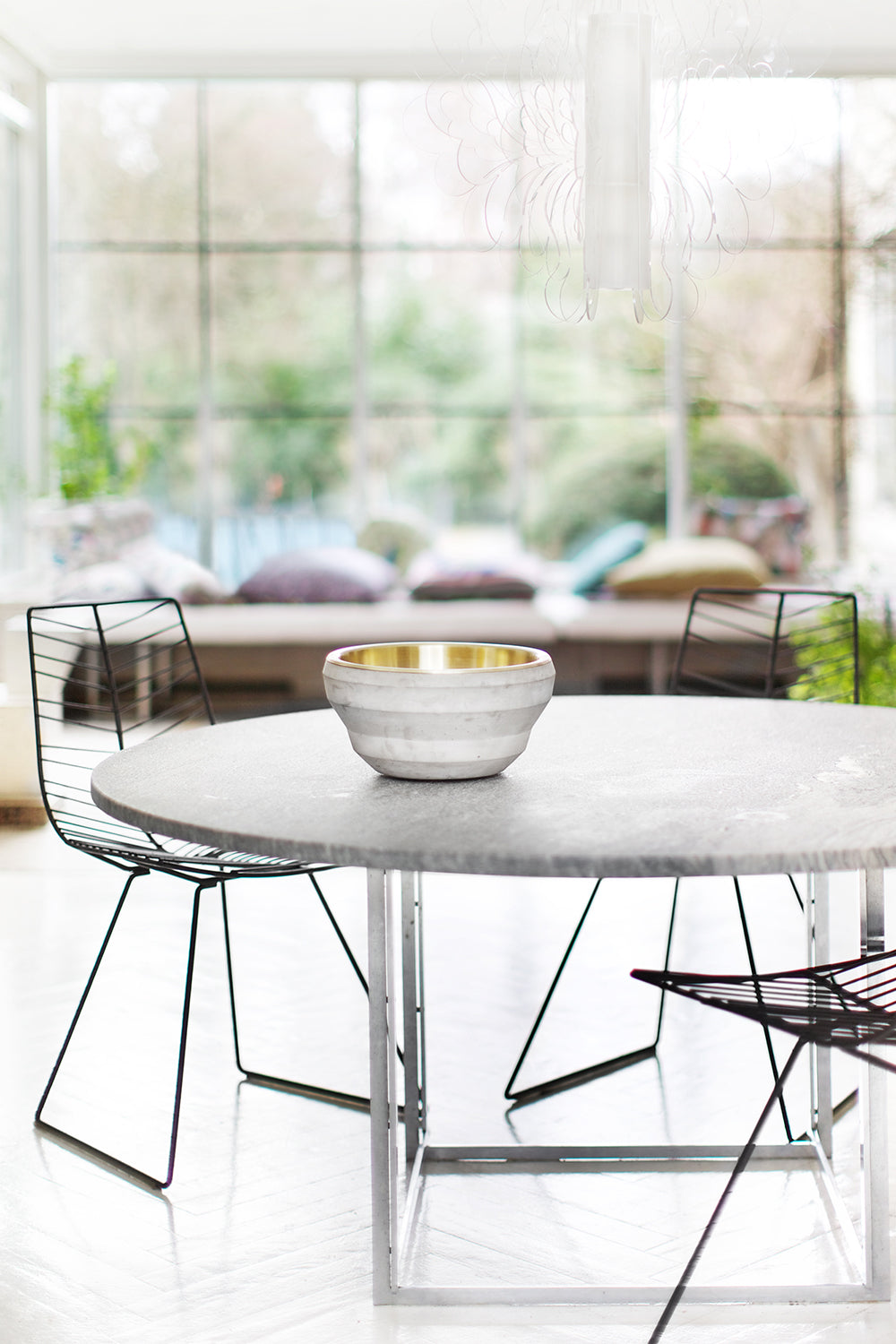 Bowl Job concrete and brass bowl on a marble dining table by Maison Burgos