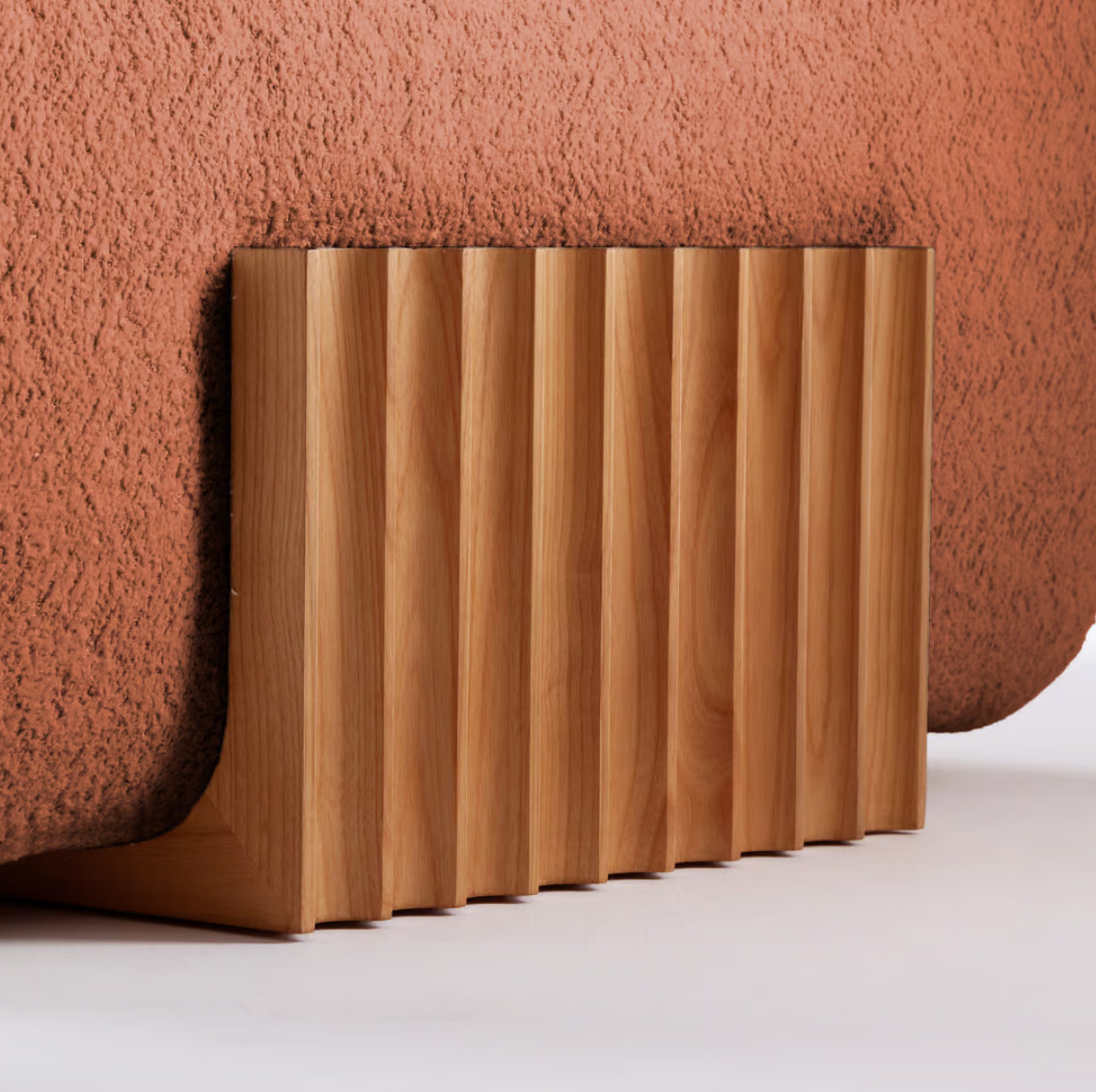 Carmel Chair fluted wood panel detail against rust bouclé