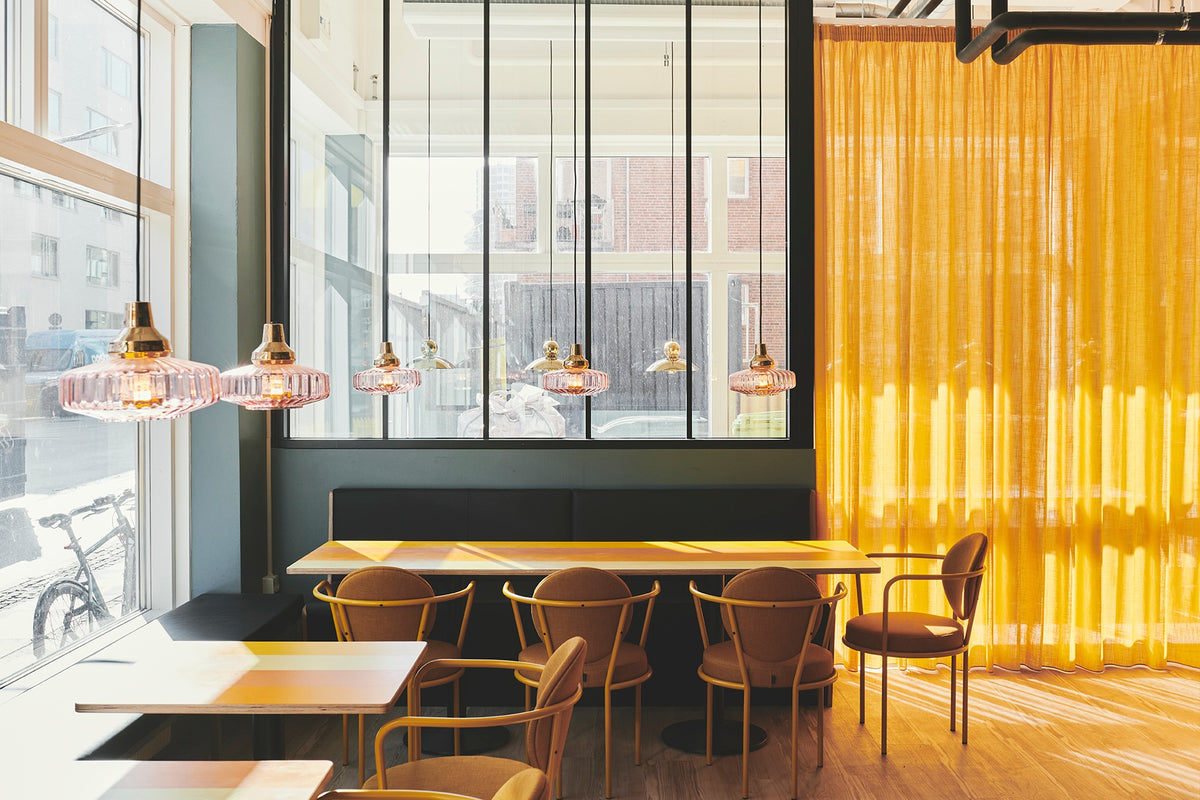 Casablanca Chairs with orange frames in a sunlit cafe by Maison Burgos