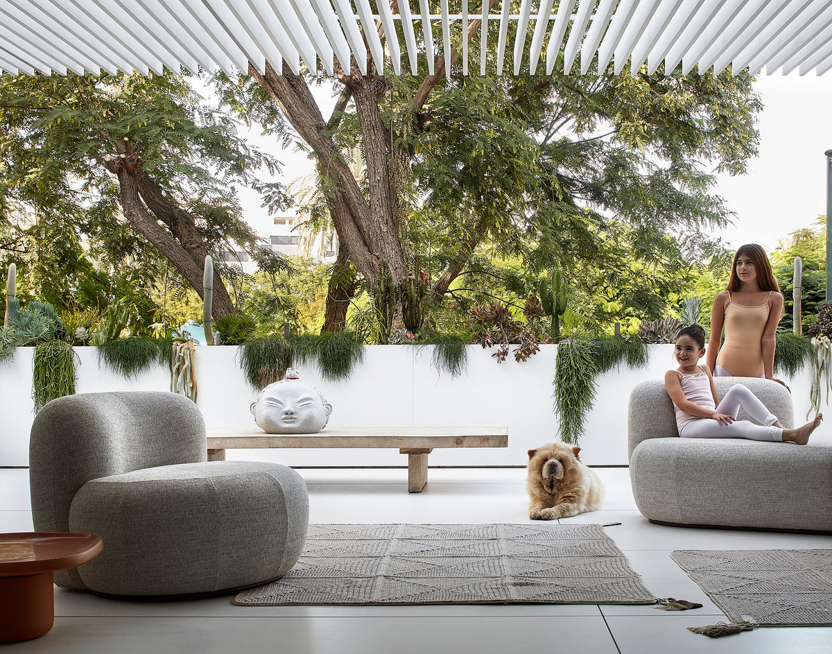 Chapter Two Sofas in grey bouclé on a shaded terrace with a dog