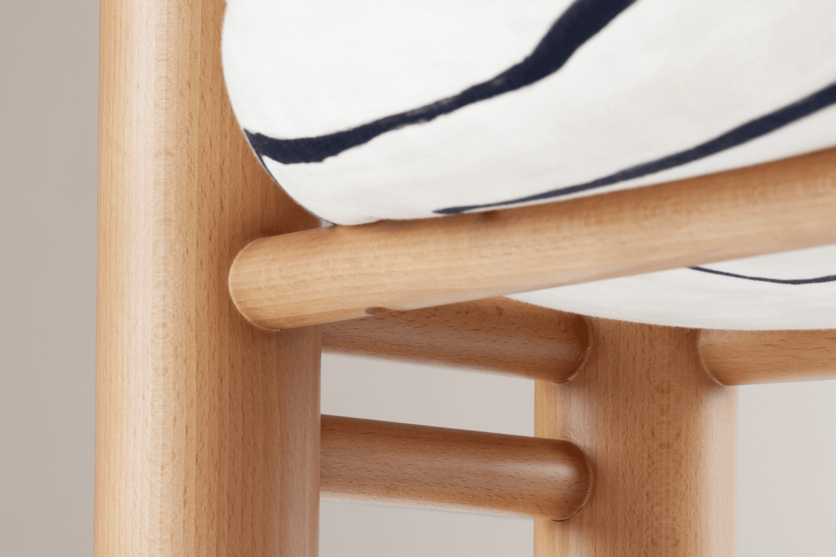 Aimi Chair close-up of the round wood frame under the upholstered seat