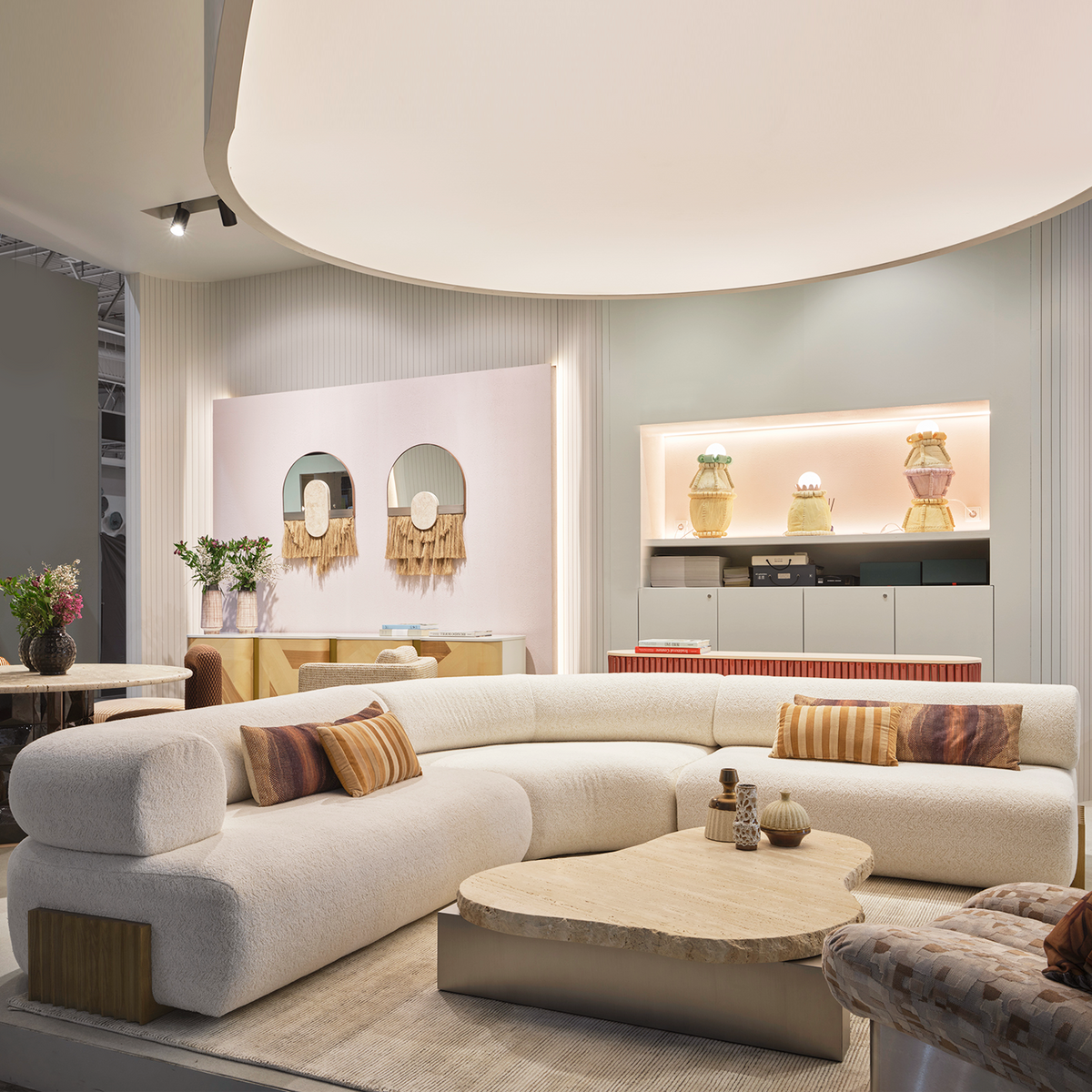 Carmel Square Ottoman in a showroom with a curved cream sofa