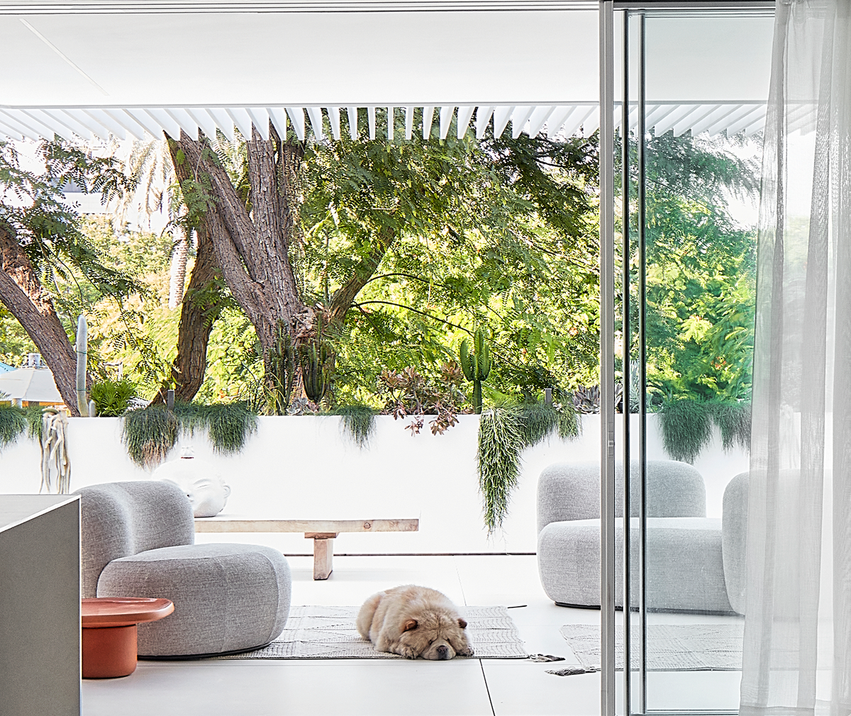 Chapter Two Sofa in grey bouclé on a covered terrace overlooking trees