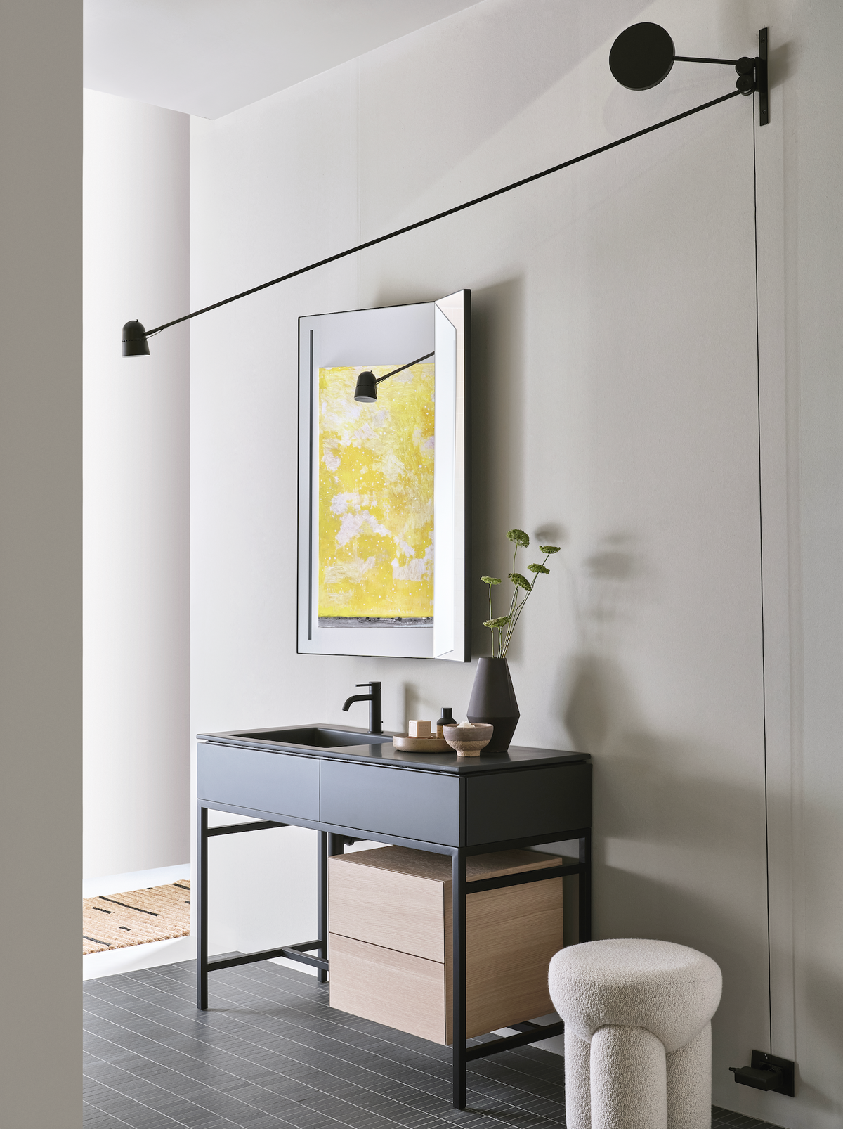 Douglas Ottoman in cream bouclé beside a dark vanity in a bathroom