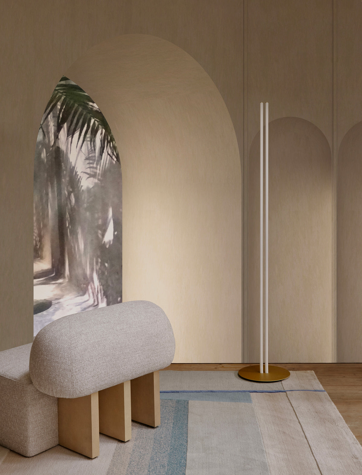 Yemeni Lounge Chair in cream boucle by an arched mural and a brass floor lamp