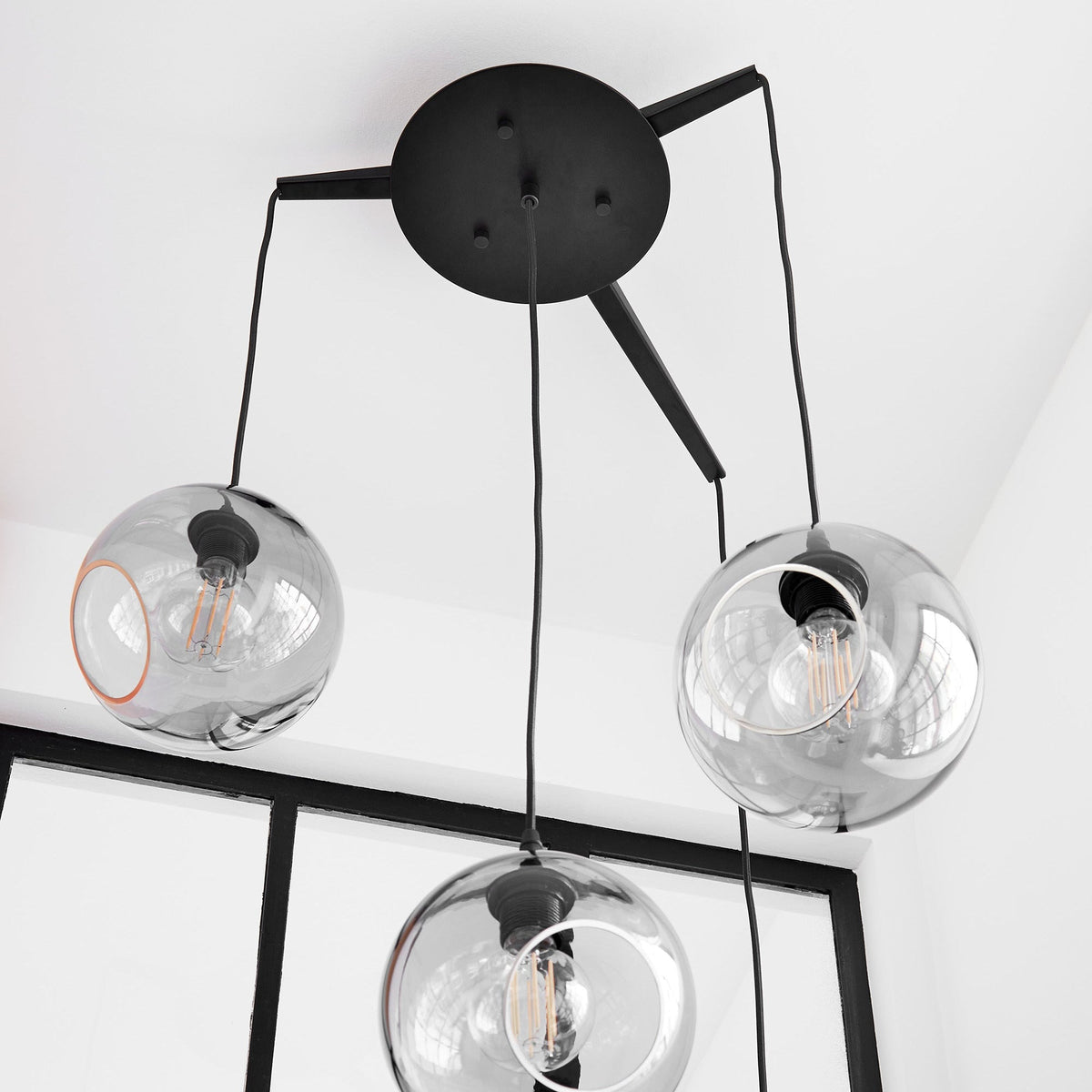 Flash Your Lamps Chandelier Light close-up of smoke glass globes under a black canopy