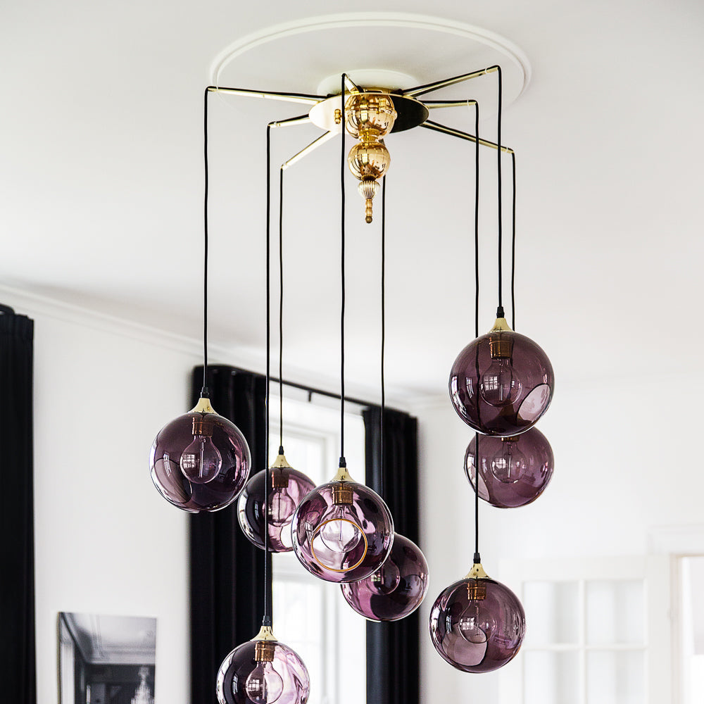Flash Your Lamps Chandelier Light with purple glass globes in a white room