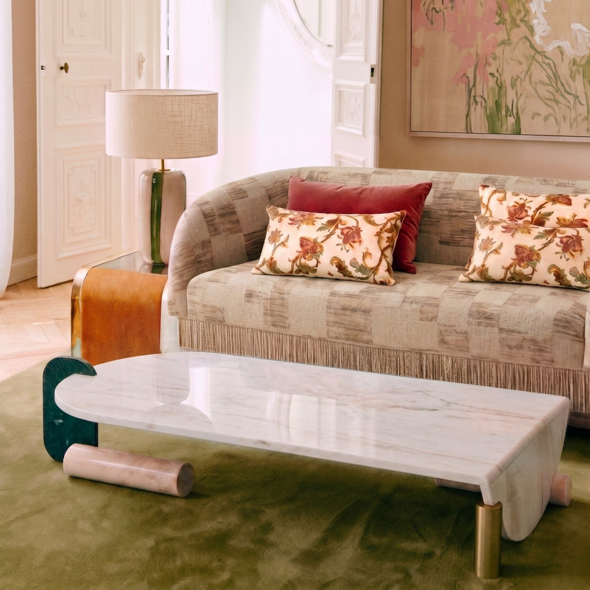 La Folie Sofa in patterned fabric with floral cushions beside a marble coffee table