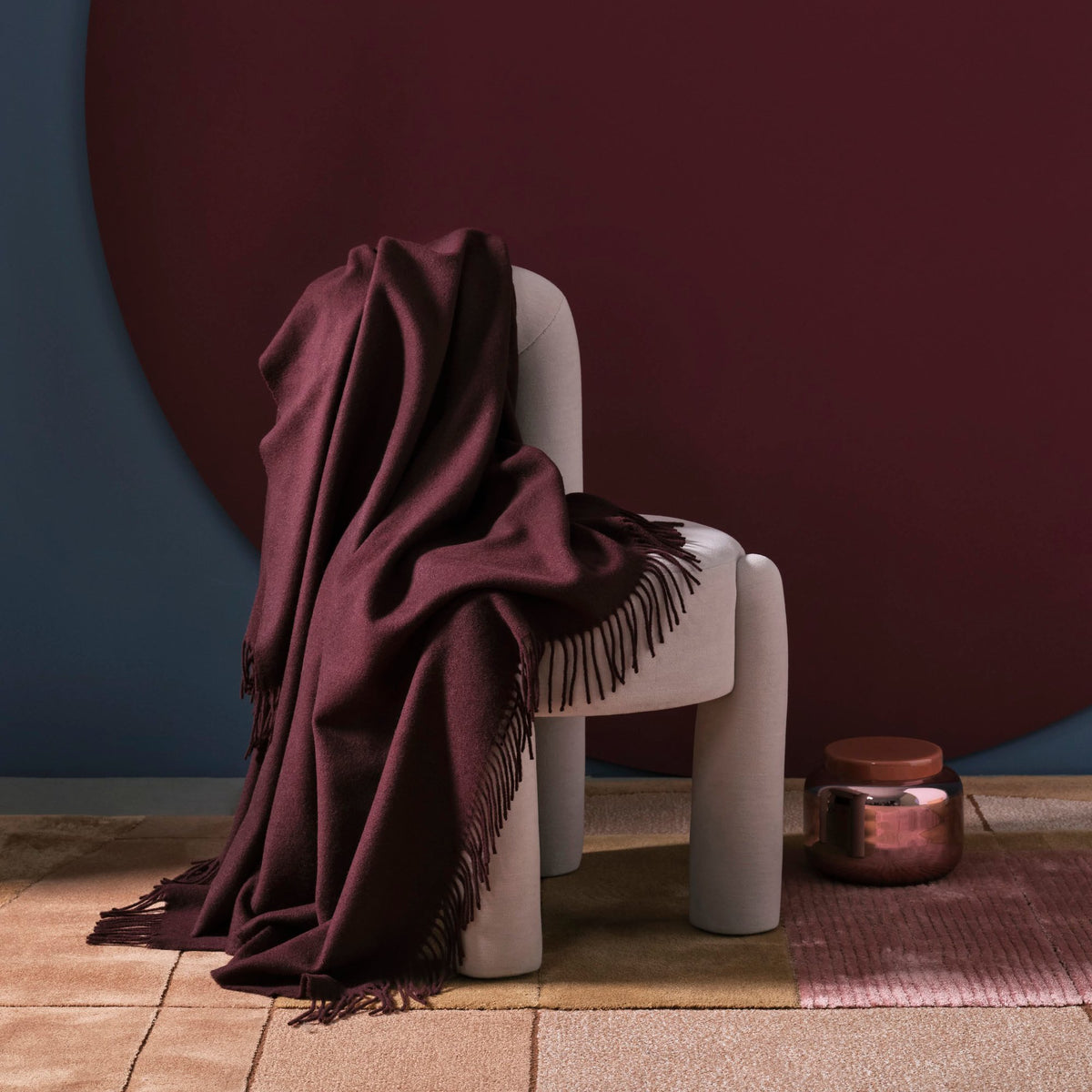 Marlon Chair in light grey with a burgundy throw against a dark red wall