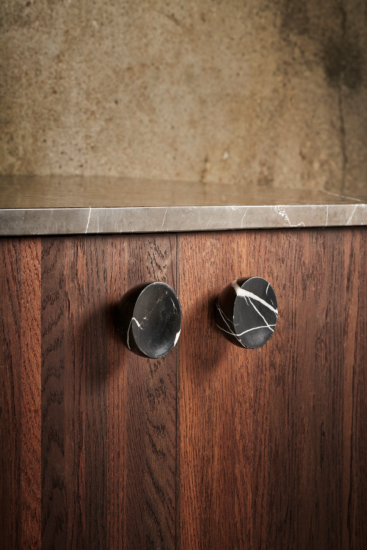Get a Grip cabinet knobs in black marble on a walnut cabinet by Maison Burgos